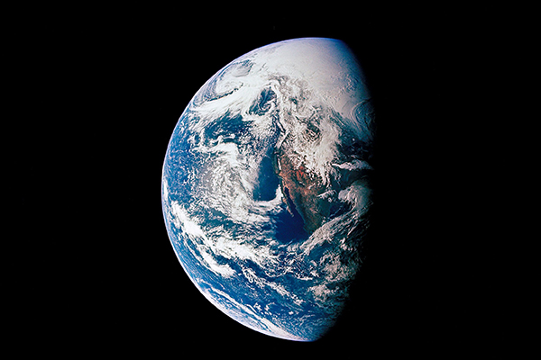 The planet Earth seen from space half-covered in sun light against a black background