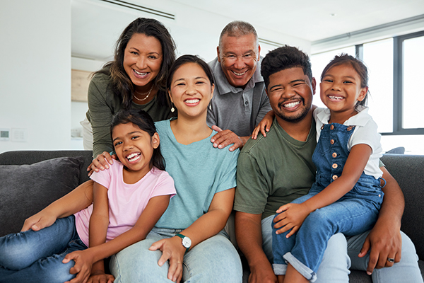 Family, children and love with kids, grandparents and parents sitting on a sofa in the living room .