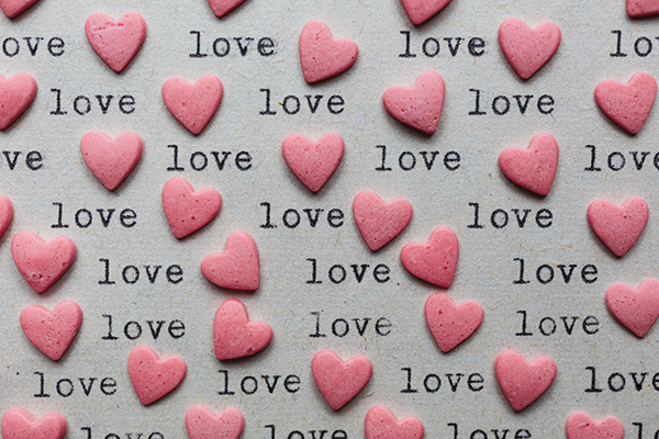 Heart shaped candy with loving words on the paper made with typewriter