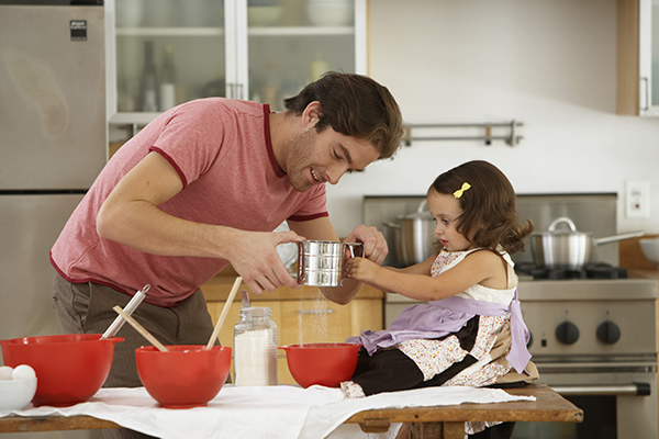 A father and daughter cook together.
